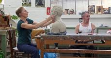 Rosi Steinbach works on the bust ›Neo‹ in the studio of Neo Rauch. [A collector had commissioned this work].
/Photo: Thomas Steinert, 2014

